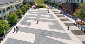 People walking and cycling through Hacker Square at Meta’s Menlo Park campus.