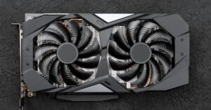 Graphics card with two cooling fans on a dark textured surface.