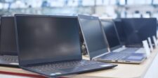 Rows of laptops on display in an electronics store, illustrating the global PC shipment decline and higher component costs.