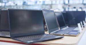 Rows of laptops on display in an electronics store, illustrating the global PC shipment decline and higher component costs.