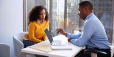 Selling a business: how to get buyer-ready before you list Business owner meeting with an advisor and reviewing information on a laptop while preparing for a potential business sale.