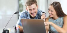 Couple shopping online with a laptop and credit card, illustrating Shopify data on AI-referred ecommerce conversions.