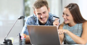 Couple shopping online with a laptop and credit card, illustrating Shopify data on AI-referred ecommerce conversions.