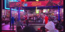 Live performers dressed as Ryu and Ken fighting inside a giant Street Fighter arcade cabinet in Times Square.