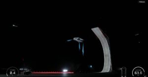 Tesla Roadster prototype hovering beside a curved stunt ramp during a nighttime demo, with blue thruster plumes and an altitude readout visible.