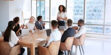 Large business team in a meeting while one person leads the discussion, illustrating the Ringelmann effect in group work.